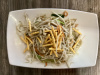 Stir fry chicken strips with bean sprouts , comes with a package of dried noodles.